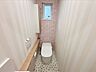 トイレ：1Fトイレです。アクセントクロスがおしゃれなデザインです。※写真はAI加工により家具等を消去しています。現況と異なる場合は現況を優先します。