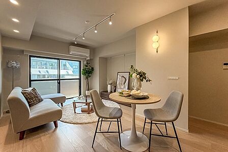 明るい色味で木目の凹凸を感じられるアッシュ材のフローリング、ベージュのクロス、ウォルナット柄のキッチンの面材を採用し、やわらかさと重厚感の塩梅がちょうどいい空間に仕上げました。