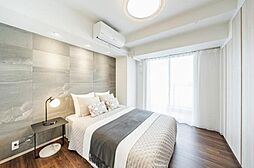 大きな窓から光が差し込む、明るく開放的な寝室。 モノトーンの壁面が、モダンで洗練された雰囲気を醸し出します。