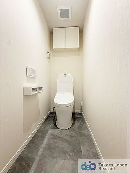 ウォシュレット機能付きのトイレは壁掛けリモコンの上位グレードを採用。便座がスッキリした印象となり、限られた空間を広く見せる効果があります。