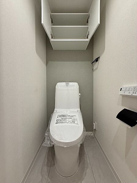 上部に吊戸棚式収納を配置した温水洗浄便座付トイレ