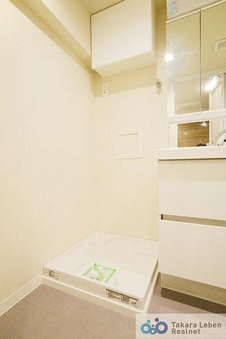 洗濯機置場。収納棚が設置されている為、洗剤類の収納場所としてお使いいただけます。