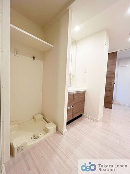 洗濯機置場。上部に棚が設置されている為、洗剤類の収納場所としてお使いいただけます。