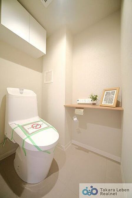 ウォシュレット機能付きのトイレは壁掛けリモコンの上位グレードを採用。便座がスッキリした印象となり、限られた空間を広く見せる効果があります。