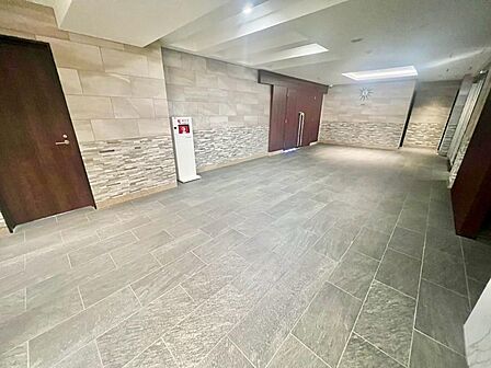 共用部/石材調の壁面と落ち着いたトーンの床材で統一されたエントランスホールは、まるでホテルのような佇まい。住まいへの帰宅時間を、少し特別な気分にしてくれます。
