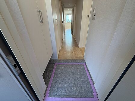 玄関を開けると、明るい廊下が奥へと続きます。収納力のあるシューズボックスが、すっきりとした玄関空間を保ちます。