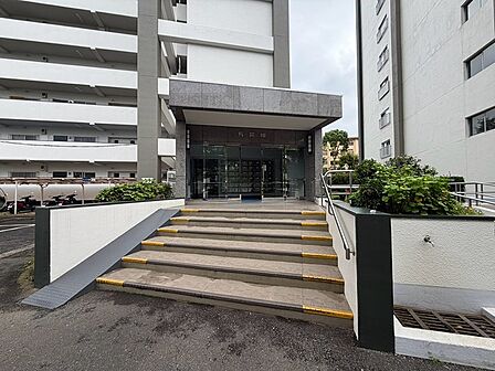 洗練された石造りのエントランスが、住まいの顔として上質な印象を与えます。段差にはスロープも設けられ、配慮が感じられます。