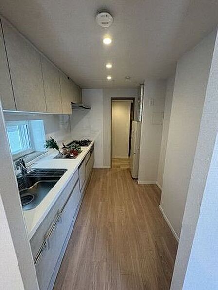 自然光が差し込む明るい窓付き！洗練されたグレージュカラーのシステムキッチン。。上下に収納スペースもたっぷり用意されています