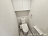 トイレ：手洗い器付きのタンクを備えた、使い勝手の良いトイレ空間です。上部には扉付きの吊り戸棚を設置しており、トイレットペーパーなどの備品を人目に触れず収納できます。