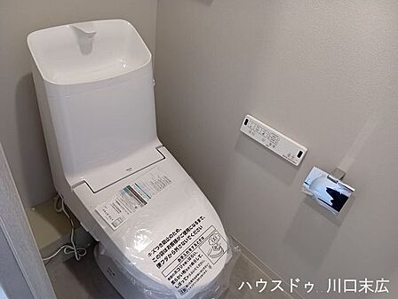 手洗い機能を備えた温水洗浄便座付きのトイレ空間。凹凸の少ないプレーンなフォルムで、日々の拭き掃除などのメンテナンスもスムーズです。