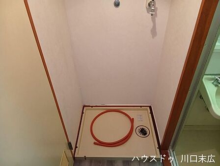 生活動線に配慮して配置された洗濯機置場。防水パンを備え付け、日々の家事をスムーズに行うための実用的なサニタリースペースです。