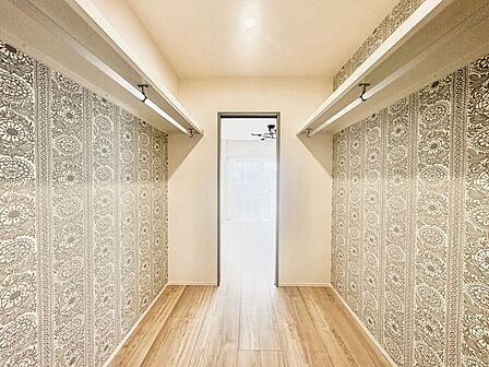 2つの居室から出入りできる、使い勝手の良いウォークインクローゼット。ボタニカル柄のアクセントクロスがかわいい、こだわりの収納空間♪