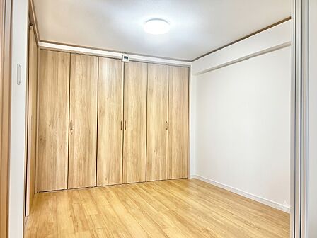 服も大型荷物もすっきり収まる壁一面の大容量収納が魅力!明るいナチュラルオーク調の木目フロアと扉が心地よい空間を演出。引き戸で隣室と繋がるフレキシブルで快適な個室空間です。