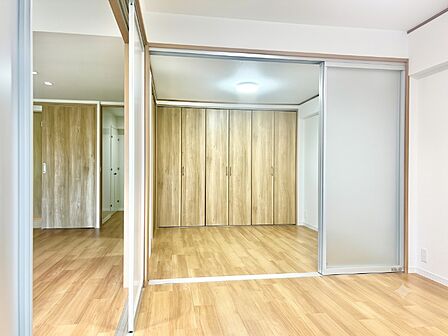光を通す半透明引き戸で隣室と繋がる伸びやかな居室!壁一面の6枚折れ戸大容量クローゼットを完備し、服も荷物もすっきり格納。木目の温もりに包まれた、機能性と開放感を兼ね備えたフレキシブル空間です。