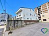 その他：《建物外観》建物側面には塀やフェンスが設けられており、敷地の奥行きや隣地との位置関係も確認できます。落ち着いた色合いの外観が周辺の街並みに調和しています。
