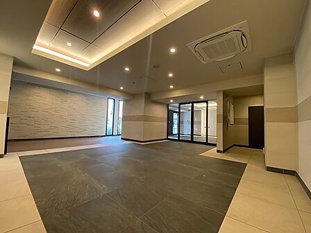 折上天井が優雅な広がりを魅せるエントランスホールは、様々な質感の素材で構成された寛ぎの空間。