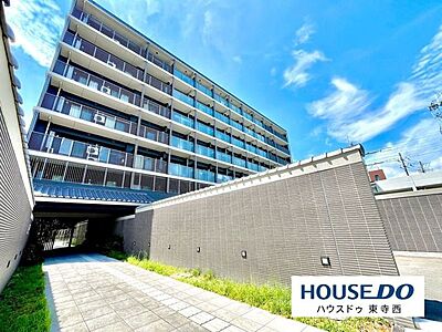外観：青空に映えるすっきりとした外観。建物の規模感や敷地周辺の様子も確認できる一枚です。