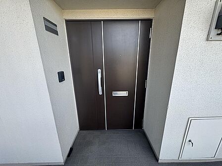 重厚感のある落ち着いた色合いの玄関ドア!安心感を与える頑丈な造りで、防犯面にも配慮されています。毎日の出入りを気持ちよくサポートしてくれますね!