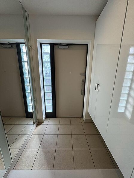 白を基調とした明るく清潔感のある玄関スペース。大きな姿見が備わっており、お出かけ前の身だしなみ確認にも便利です。玄関収納も備えているため、靴や小物類をすっきり整理しやすい空間となっています。