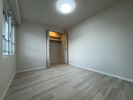 窓からの光と淡い木目の床が柔らかな印象をつくる洋室。クローゼットを備え、衣類をまとめて収納できます。白を基調とした内装は家具も合わせやすく、寝室や書斎など、家族の暮らしに合うお部屋づくりを楽しめます。