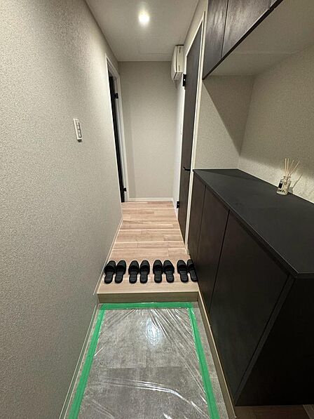 落ち着いた色合いでまとめられた玄関。右側には収納が備わり、靴や小物をすっきり片付けられます。廊下へ続く動線もシンプルで、帰宅時や来客時の使い勝手を想像しやすい空間です。収納量は現地でご確認くださいね。