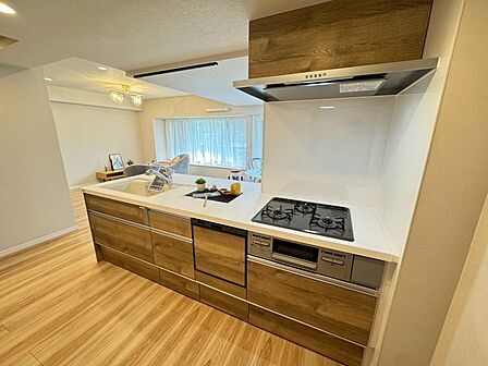 木目調のデザインが映える、開放的な対面式キッチン。リビングを見渡しながら料理を楽しめます。収納スペースも豊富で、調理器具や食器類もすっきり整理。家族との会話が自然と弾む、家事がより楽しくなる空間です。