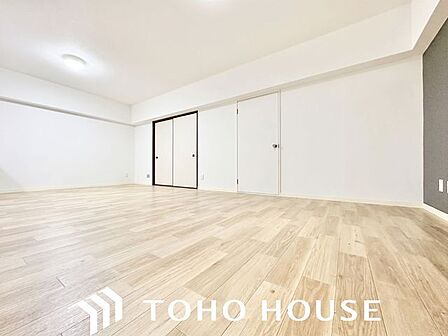 ナチュラルな木目調の床から木のぬくもりを感じられる14帖のリビングルーム。（画像処理技術で空室イメージを再現しています。）