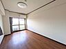 洋室：温かみのある木目調フローリングのお部屋。大きな窓からやわらかな光が差し込みます。