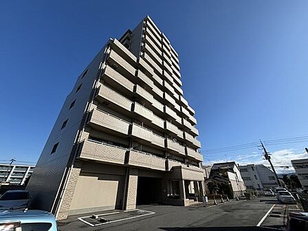 落ち着いた色合いの外観タイルが印象的なマンション。青空に映えるスタイリッシュな佇まいです。