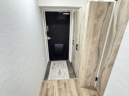 【玄関】木目の建具と白を基調に整えた、すっきりとした玄関スペース。