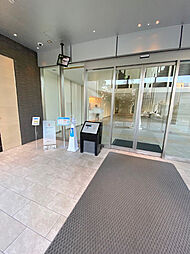 御影石のブリッジを渡りメインエントランスへ。吹抜けのホールでは光のシンボルツリーがお迎えします