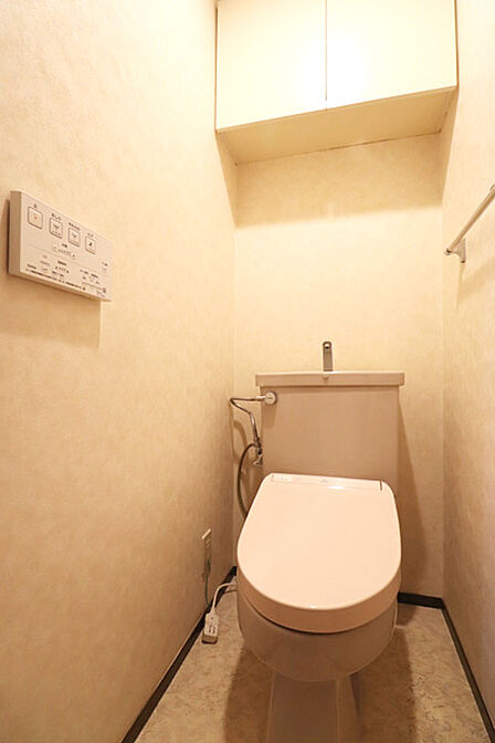 トイレには快適な温水洗浄便座付き。トイレットペーパー他、収納に役立つ上部戸棚を設置しています。