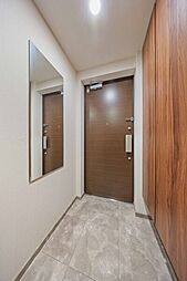 人感センサー照明や鏡が備わった玄関。玄関から廊下にかけて、大容量の下足入＆物入が設けられています。【玄関】
