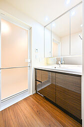 洗面化粧台は幅が広いため、ご家族でも使用しやすいです。三面鏡裏には化粧品などが収納可能です。【洗面室】