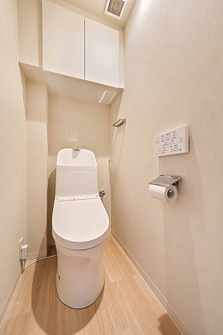 ※販売対象に家具・調度品は含まれません。快適にご使用いただける温水洗浄便座付きのトイレです。吊戸棚が備え付けられています。
