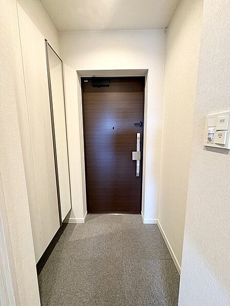 玄関は明るく上品な仕様。全身鏡が備え付けられており、お出かけ前に身だしなみをチェックできます。【玄関】