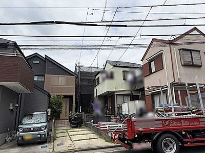 外観：中央奥の工事中の建物が本物件でございます。