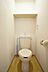 室内：トイレの写真になります。上部には収納棚があります。