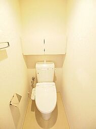 多機能便座付のトイレです。後ろには開き戸の収納スペースがあり、備品を綺麗に収納出来ます。