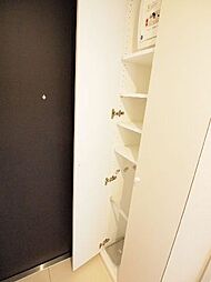両開きの扉の下駄箱です。高さを変えられる棚や傘立てもあり便利に使えます。玄関ドアにはドアスコープも付いています。