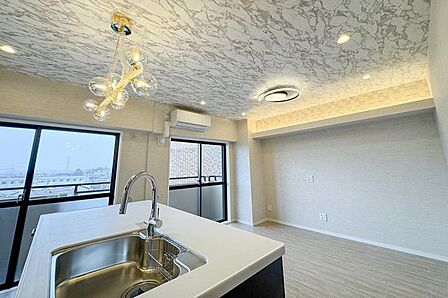 天井のモダンなデザインクロスとこだわりを感じる照明