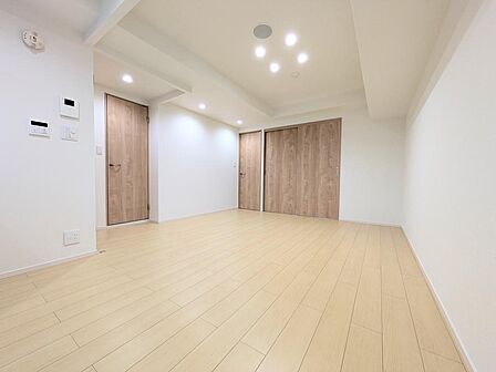 LDK10.8帖。木目調の床・建具を採用し、ダウンライトで明るい雰囲気のリビングです。