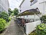 その他：屋根付きの敷地内駐輪場。雨から自転車を守り、管理状況も良好です。敷地内には緑豊かな通路が続きます。