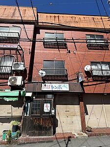 外観：【現地外観】赤茶色のタイル張りが目を引く、味わいのある外観。1階にはシャッター付きの店舗部分があります。