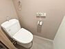 トイレ：日々の心地よさを細部まで追求した、シンプルかつスタイリッシュなトイレ空間。壁面には温かみのあるニュアンスカラーのアクセントクロスをあしらっています。