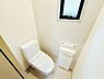 トイレ：明るい室内に設置されたトイレです。小窓から自然光が入るので圧迫感の少ない空間です。操作パネルや収納も備わっています。シンプルで清潔感があります。