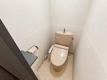 シンプルで清潔感のあるトイレ空間です。コンパクトながらスペースの有効活用がされています。手洗い付きのタンクが設置されています。ペーパーホルダーも使いやすい位置に配置されています。