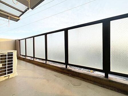 広々としたバルコニーはしっかりとした柵が設置されており安心感があります。ガラスパーテーションで外からの視線を遮りプライバシーを保てます。空が広く見える開放的な空間です。物干し金具も備わっています。