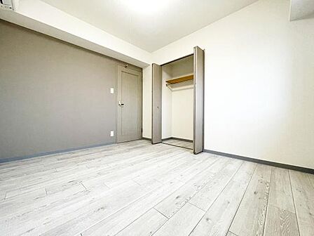 淡い色合いのフローリングが空間を広く感じさせます。クローゼット付きで整理整頓にも便利です。壁面のアクセントカラーが室内に落ち着いた印象を与えています。