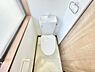 トイレ：トイレは明るい採光があり清潔感のある空間です。壁にはペーパーホルダーやタオルリングも備わっています。床や壁の色味が落ち着いておりシンプルなデザインが特徴的です。日常の使いやすさを感じられる設計です。